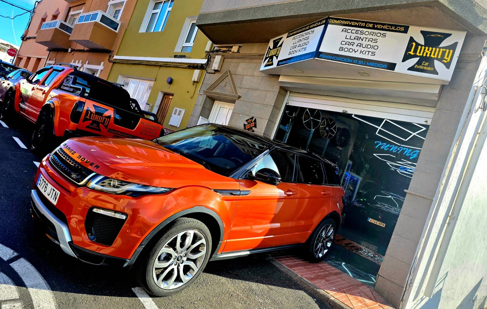 Fachada de Luxury Car Performance con Range Rover Evoque naranja