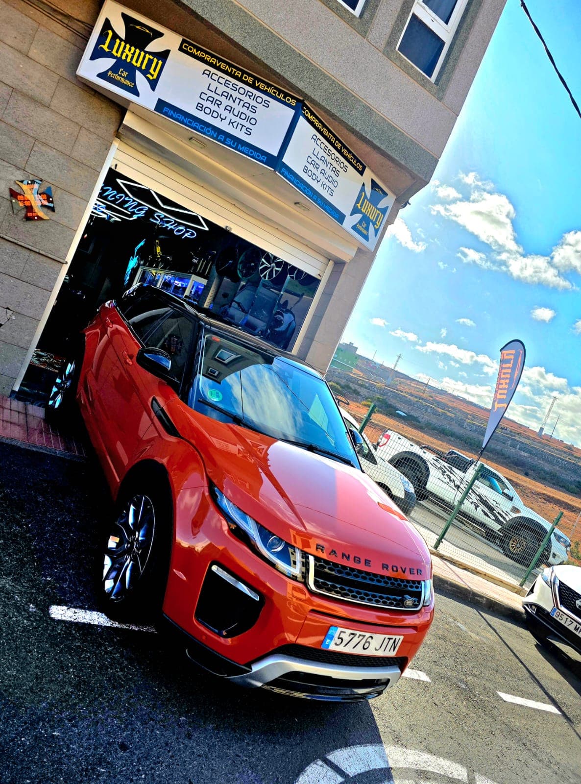 Fachada de Luxury Car Performance con Range Rover Evoque rojo